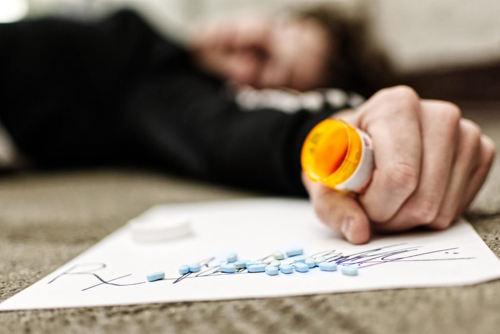 Person on the floor addicted to painkillers